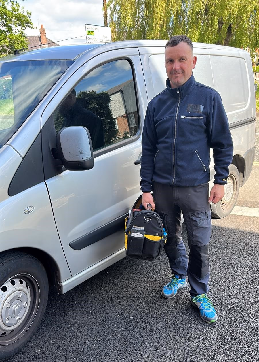 Vitaly Selickis standing beside his LockMend service van with a tool bag